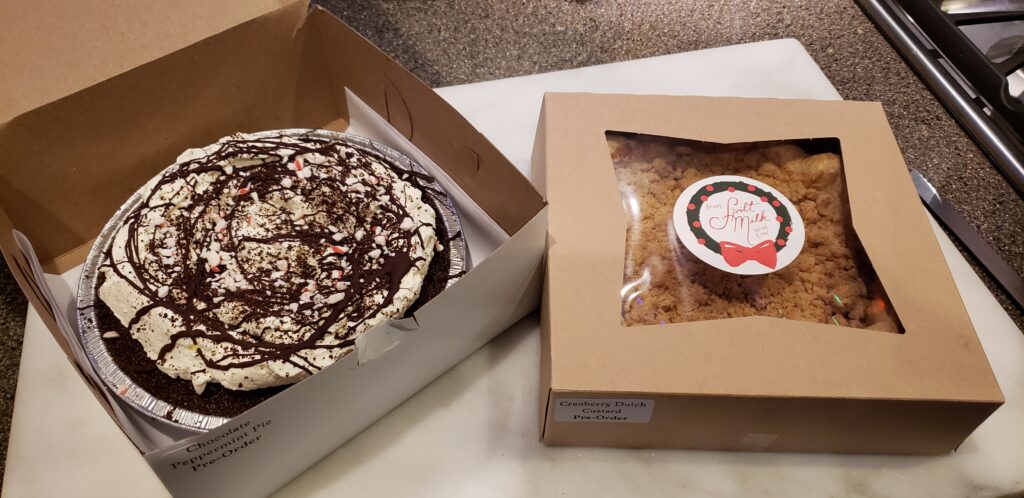 Two pies side by side on a counter. Left: Chocolate peppermint. Right: Cranberry custard walnut.